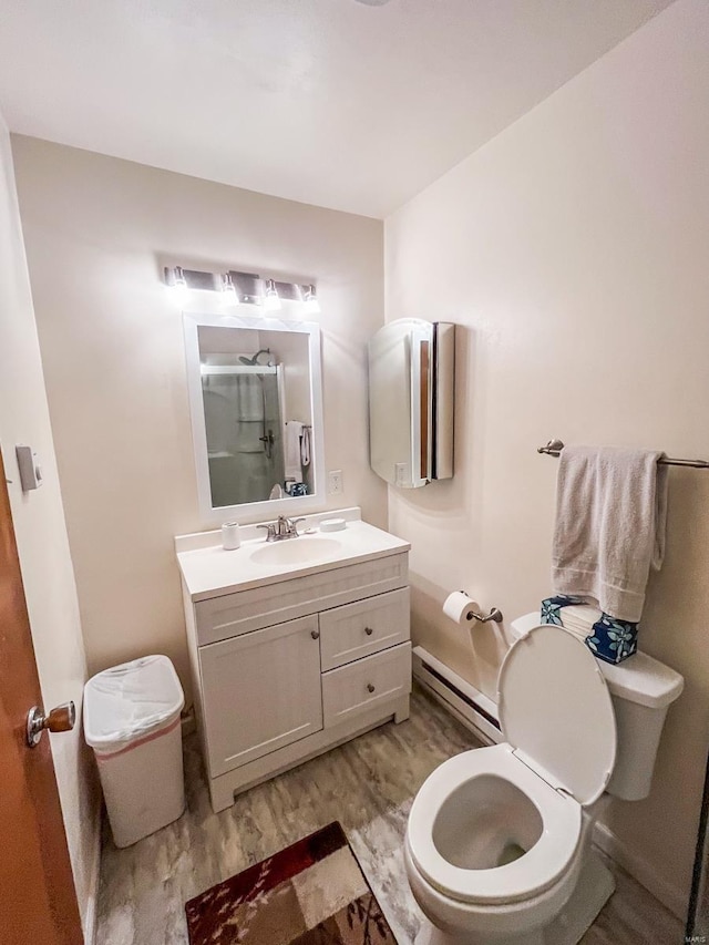 bathroom with hardwood / wood-style floors, vanity, toilet, a baseboard radiator, and an enclosed shower