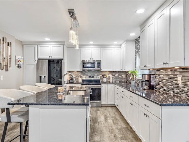 kitchen with sink, a center island with sink, white cabinets, and appliances with stainless steel finishes