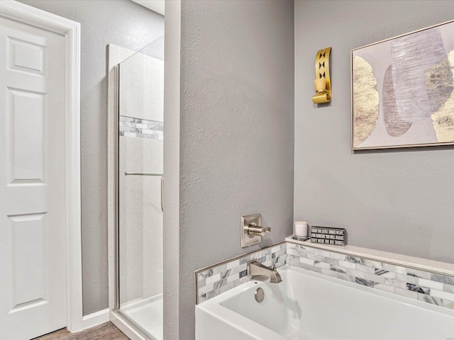 bathroom featuring shower with separate bathtub