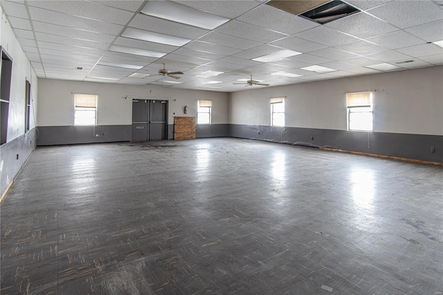 empty room featuring ceiling fan and a drop ceiling