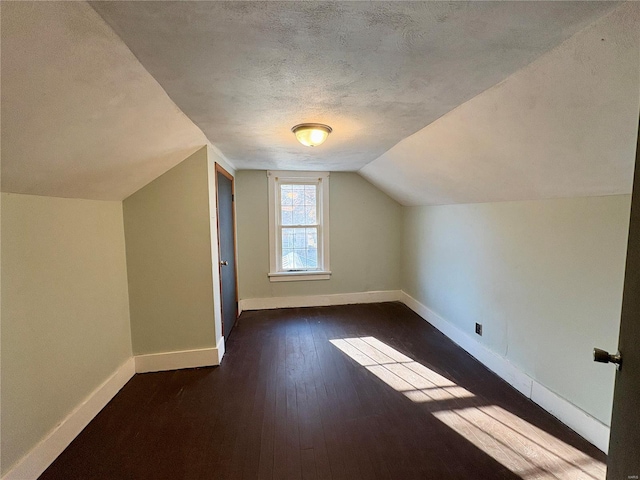 bonus room with vaulted ceiling, a textured ceiling, and dark hardwood / wood-style floors