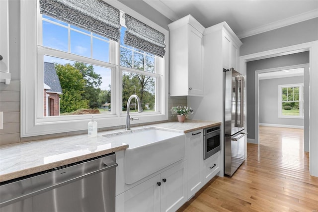 kitchen with sink, light stone counters, white cabinetry, and stainless steel appliances