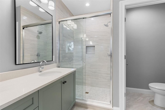 bathroom featuring vanity, toilet, and a shower with shower door