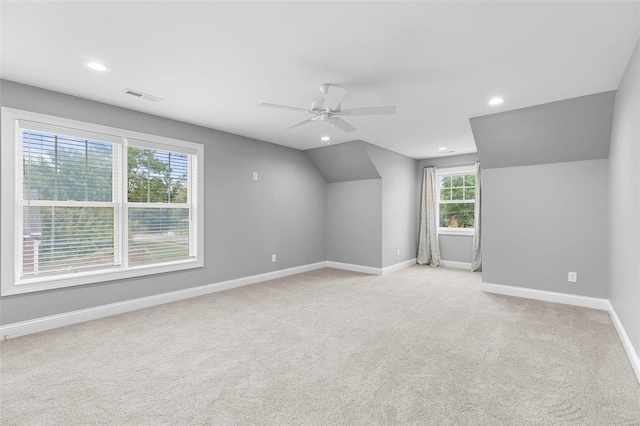 bonus room featuring ceiling fan, a healthy amount of sunlight, light colored carpet, and lofted ceiling