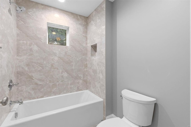 bathroom with tiled shower / bath combo and toilet