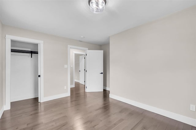 unfurnished bedroom with dark hardwood / wood-style floors and a closet