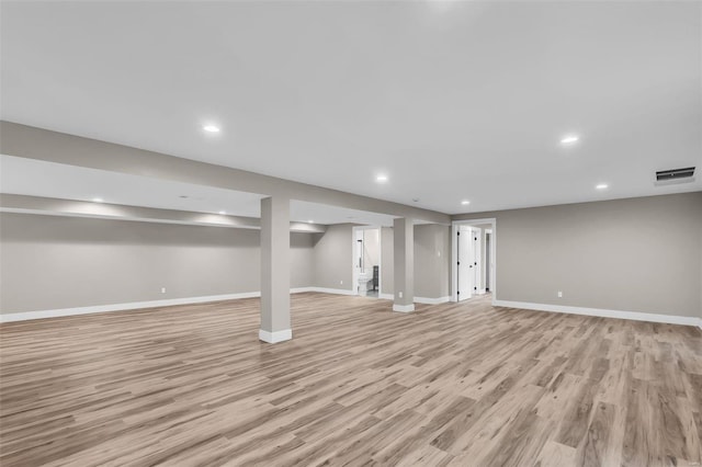 basement with light hardwood / wood-style flooring