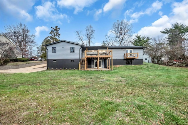 rear view of house with a deck and a lawn