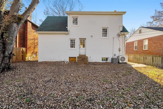 back of property with ac unit and central AC