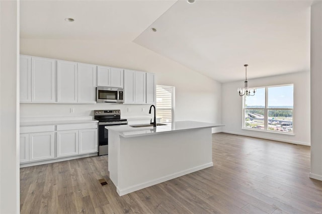 kitchen with white cabinets, sink, stainless steel appliances, and an island with sink