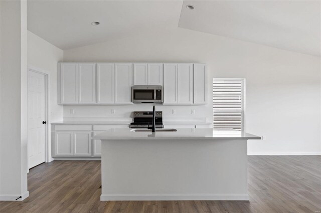 kitchen with white cabinetry, stainless steel appliances, a kitchen island with sink, and vaulted ceiling