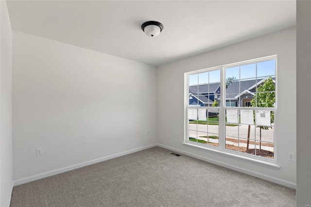 carpeted spare room featuring plenty of natural light