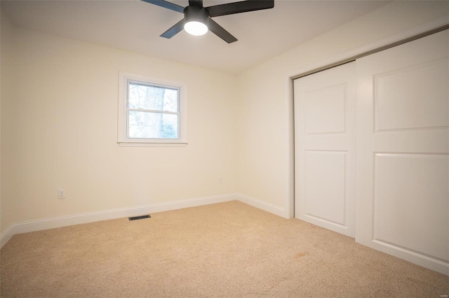 unfurnished bedroom with ceiling fan, carpet flooring, and a closet