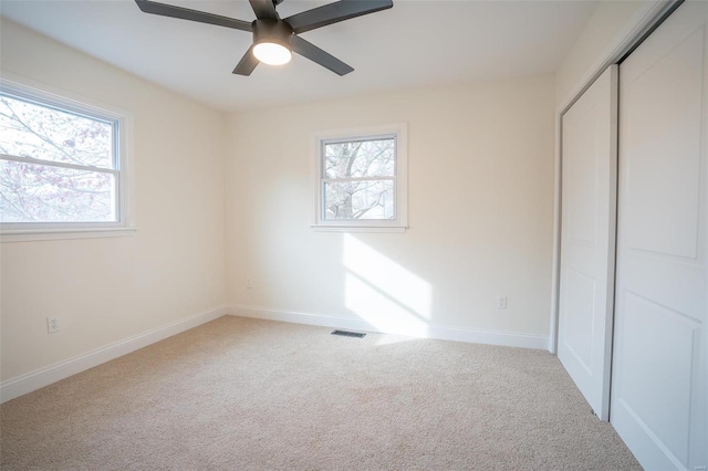 unfurnished bedroom with ceiling fan, a closet, and carpet