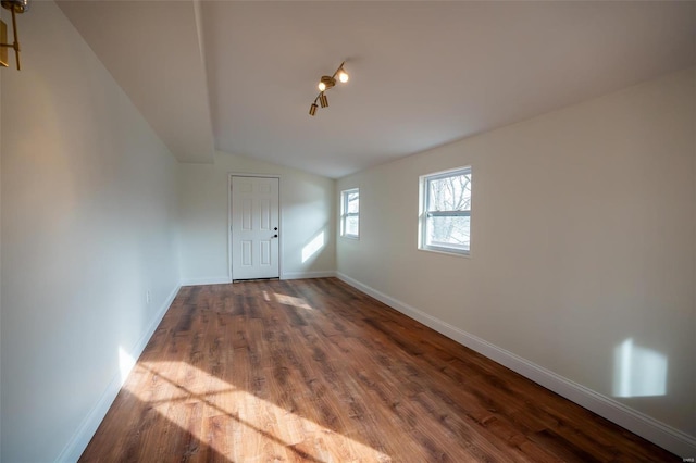 foyer entrance with vaulted ceiling and hardwood / wood-style floors