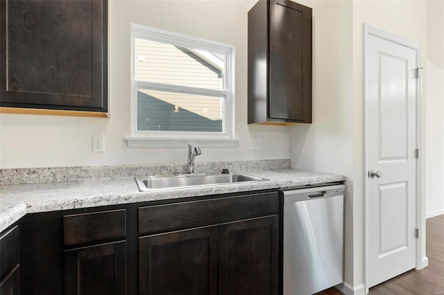 kitchen featuring dark brown cabinetry, sink, stainless steel dishwasher, and dark hardwood / wood-style floors