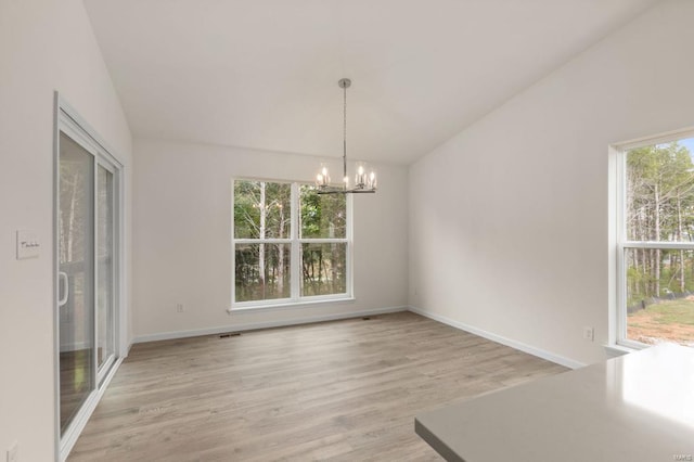 unfurnished dining area featuring light hardwood / wood-style flooring, a wealth of natural light, and lofted ceiling