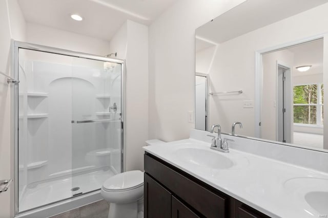 bathroom featuring tile patterned floors, vanity, an enclosed shower, and toilet