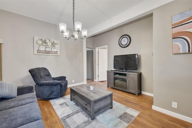 living room featuring light hardwood / wood-style flooring and an inviting chandelier