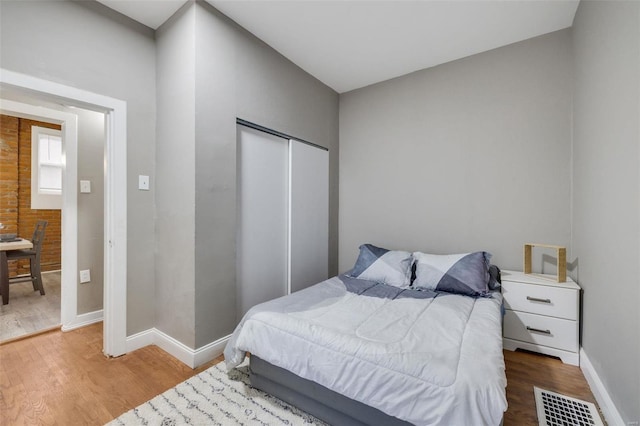 bedroom featuring wood-type flooring and a closet