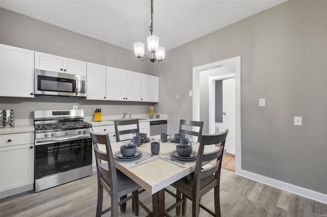 dining area with a notable chandelier and light wood-type flooring