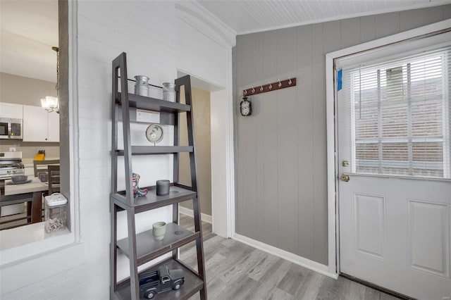 doorway with wooden walls and light hardwood / wood-style flooring