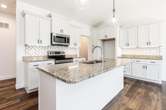 kitchen with dark wood-type flooring, white cabinets, a center island with sink, sink, and stainless steel appliances