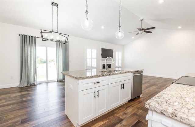 kitchen featuring dark wood-type flooring, white cabinets, hanging light fixtures, vaulted ceiling, and an island with sink