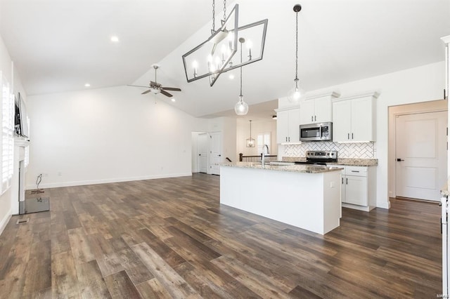 kitchen featuring stainless steel appliances, decorative light fixtures, dark hardwood / wood-style floors, white cabinetry, and an island with sink