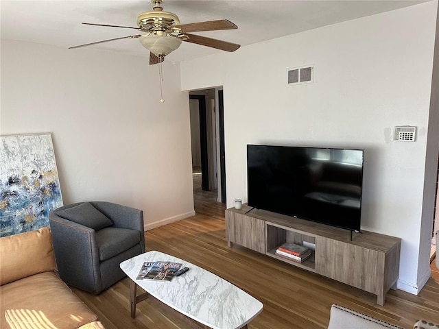 living room with dark hardwood / wood-style flooring and ceiling fan