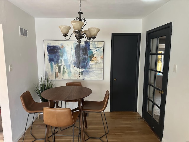 dining area featuring hardwood / wood-style floors and a chandelier