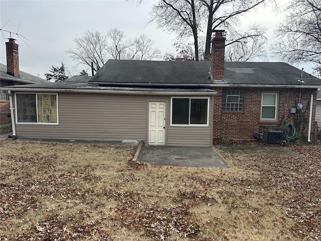 back of property featuring cooling unit, a patio area, and a lawn