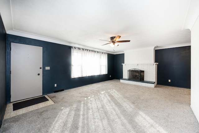 unfurnished living room with carpet flooring, ceiling fan, crown molding, and a fireplace