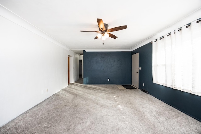 empty room featuring carpet flooring, ceiling fan, and crown molding