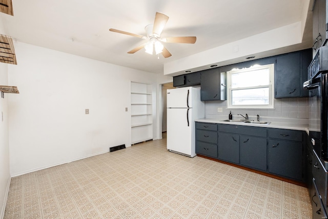 kitchen featuring white refrigerator, sink, decorative backsplash, ceiling fan, and black oven