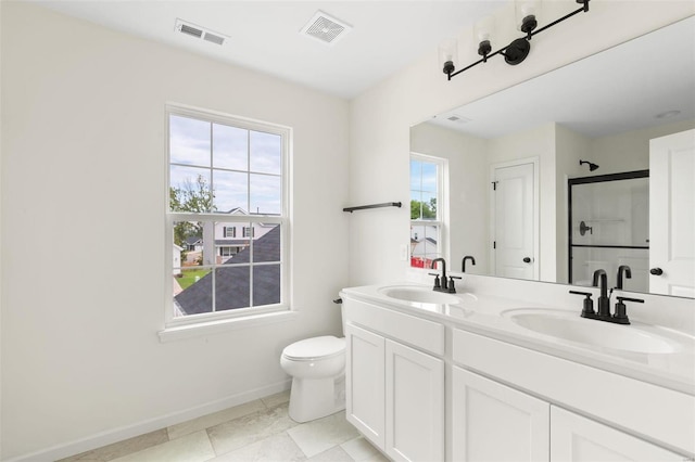 bathroom featuring tile patterned flooring, vanity, toilet, and a shower with door