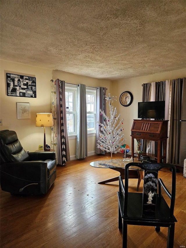 living room featuring wood-type flooring and a textured ceiling