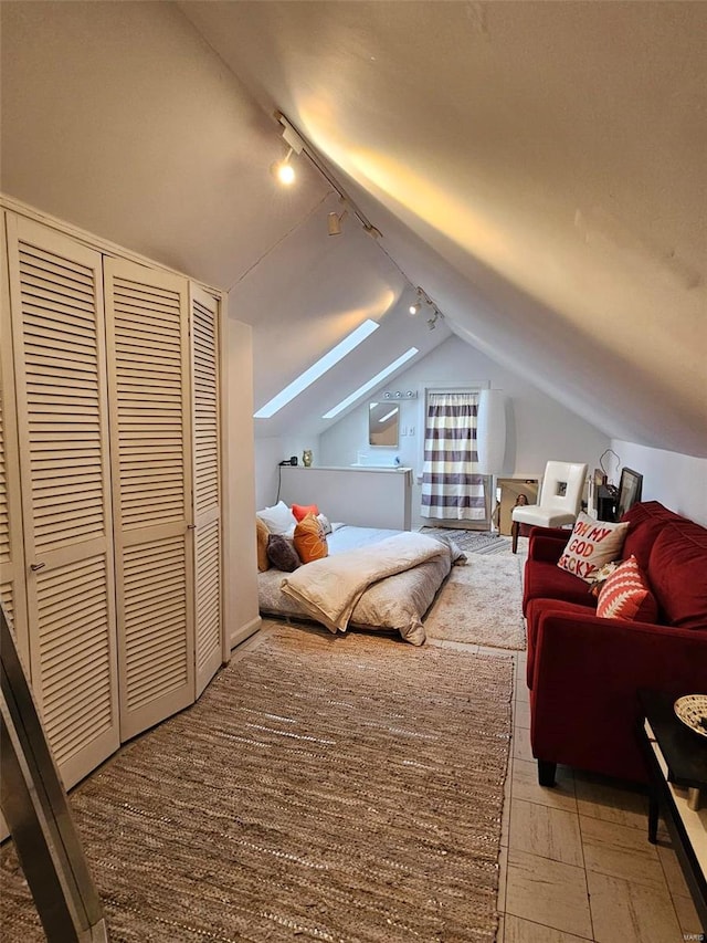 bedroom featuring rail lighting and lofted ceiling with skylight