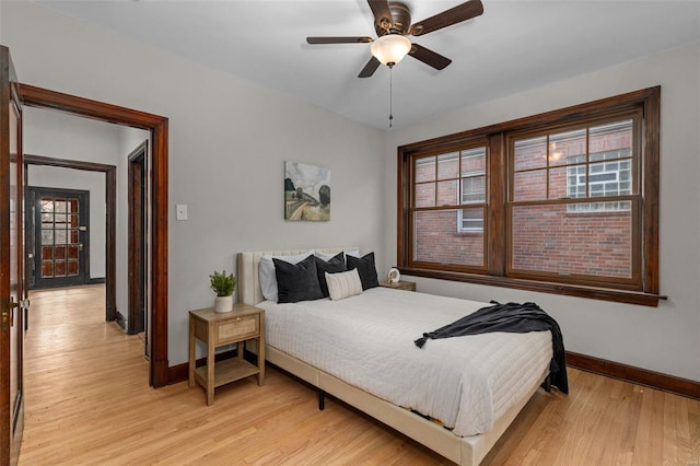 bedroom featuring multiple windows, ceiling fan, and light wood-type flooring