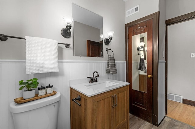 bathroom with hardwood / wood-style floors, vanity, and toilet