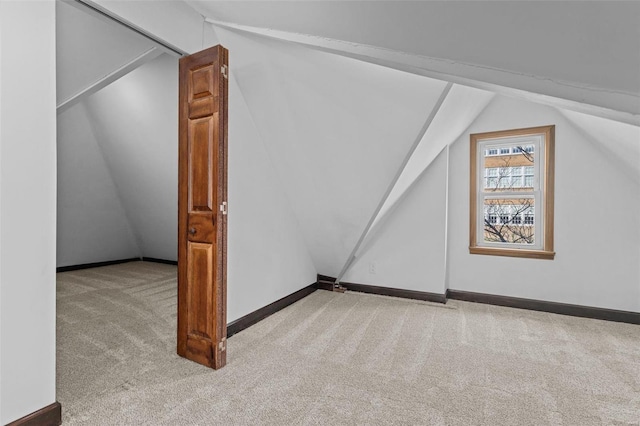 additional living space with light carpet and vaulted ceiling