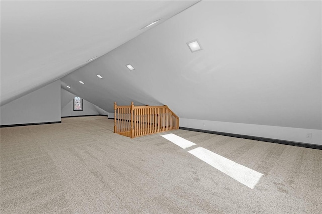 bonus room with light carpet and vaulted ceiling