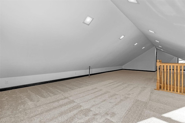 bonus room with light colored carpet and vaulted ceiling