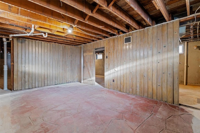 basement featuring wooden walls