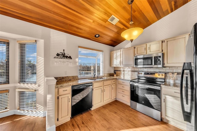 kitchen featuring visible vents, cream cabinets, vaulted ceiling, black appliances, and a sink