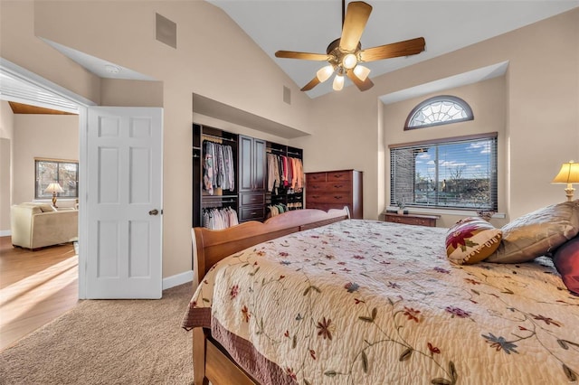 bedroom with carpet, baseboards, high vaulted ceiling, and a closet