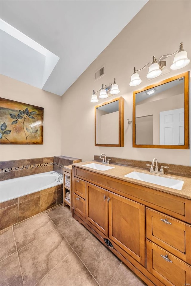 full bath with a garden tub, tile patterned flooring, visible vents, and a sink