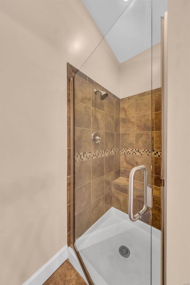 full bath featuring a stall shower and baseboards