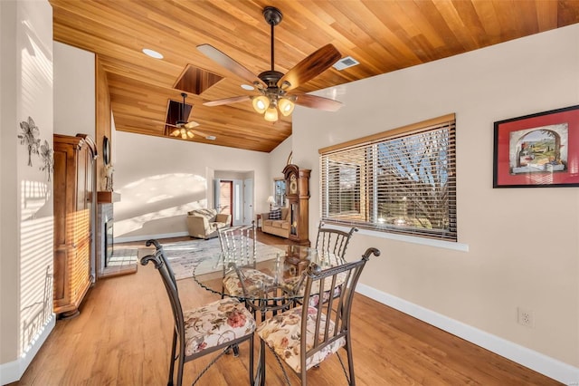 dining area featuring light wood finished floors, visible vents, baseboards, wood ceiling, and vaulted ceiling