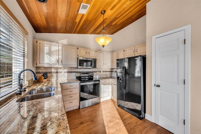 kitchen with a sink, visible vents, cream cabinetry, appliances with stainless steel finishes, and tasteful backsplash